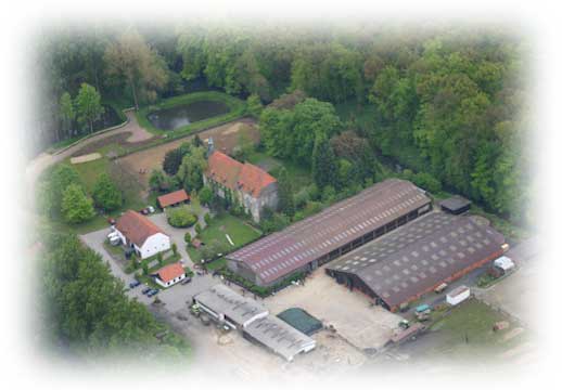 Luftbild von Gut Stockum: Gutshaus, Reithallen und Weiden zwischen Bäumen